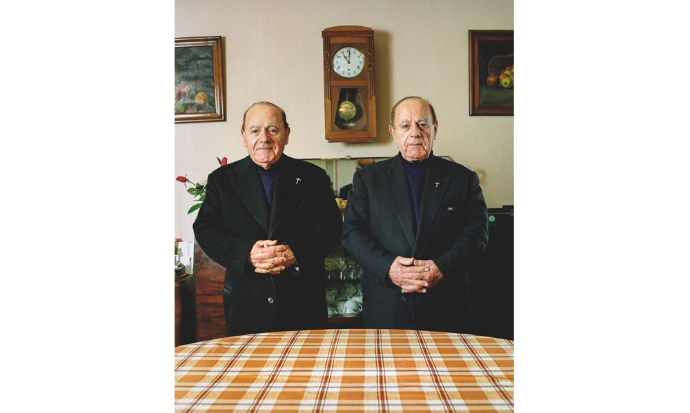 abbés jumeaux en col romain dans leur salle de séjour